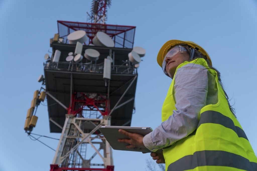 Engineer working on the field near a Telecomunications tower